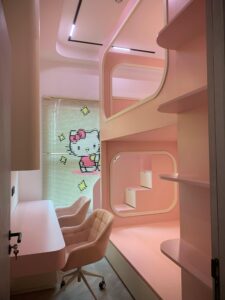 Modern pink-themed children's room with lofted beds and cozy chair.